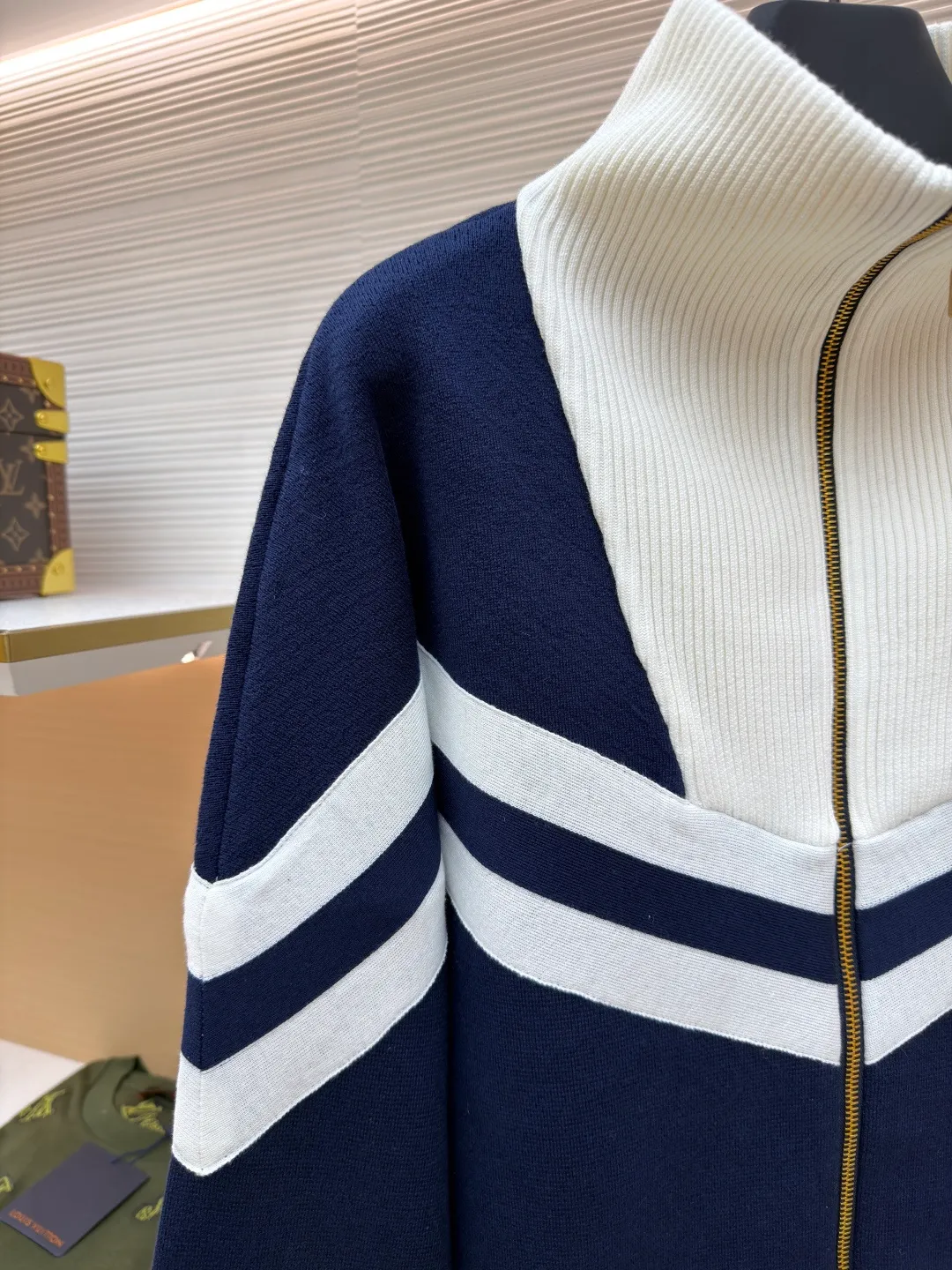 LOUISVUITTON line-tone embroidered jacket ●Original version: purchased and developed in 19899 ●Item number: 1680861-B75 ●Fabric: combed cotton fabric ●Technology: embroidery production ●Version: fitted version ●Weight: about 965 grams ●Size: S-M-L-XL ●Description: The yarn is made of [2/40 count 100% combed cotton], It is made of [14-needle computer woven piece], the whole piece is solid sesame base, [about 160 minutes], the blue and white strips are [hair hanging method], and the weaving time is longer [about 70 minutes]; when sewing, the hem ribs and cuff ribs need to be [stitched in double layers], the collar bone is wrapped so that it does not show up, [the collar needs to be sewn twice], the bottom bone and the shirt body bone are not in the same line When sewing the sleeves, you need to sew in a circle, which takes a long time to sew. After embroidering, you need to carve the blue and white strips of tape and the zipper. When flat sewing, you need to pay special attention to the straight position of the straps, which can easily become skewed. The zipper is [inside the rib position], and the collar is very high. It is difficult to sew the zipper. The entire production process requires too many steps, and the wool is white, so it is very easy to get dirty, which increases the finishing time and the defective rate. The overall wiring is straight and delicate, the fabric is comfortable and soft, and the color is consistent without color difference. It can be matched with the same style to create a fashionable look and control various occasions. Customized accessories, complete with three standards, same style for men and women!